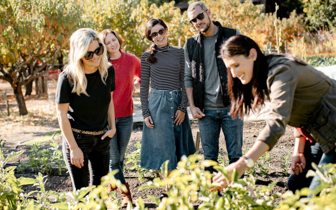 woman pointing at things in garden to a group of people