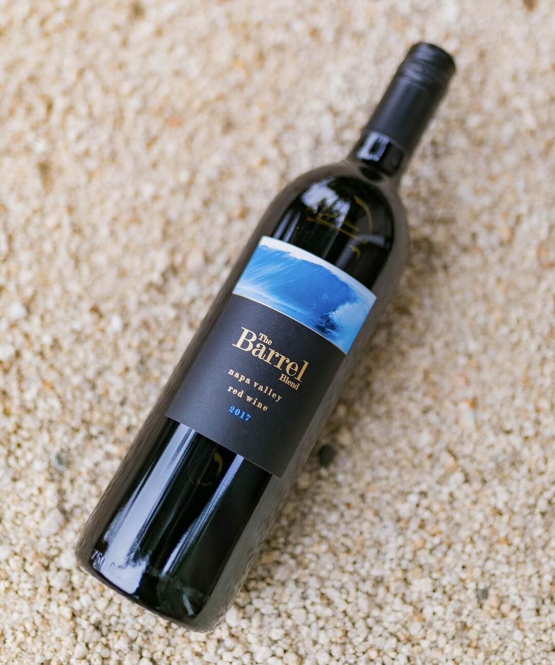 red blend wine bottle on sand