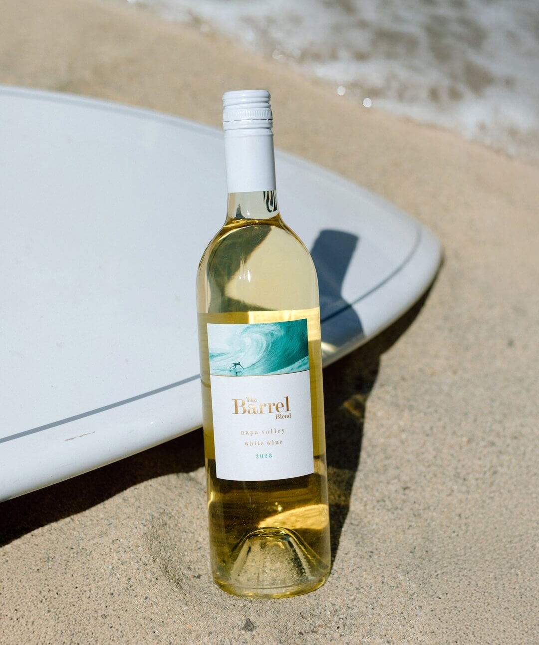 white blend wine bottle on sand