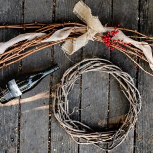 hill family estate bottle of wine on table next to wreath made of grape vines